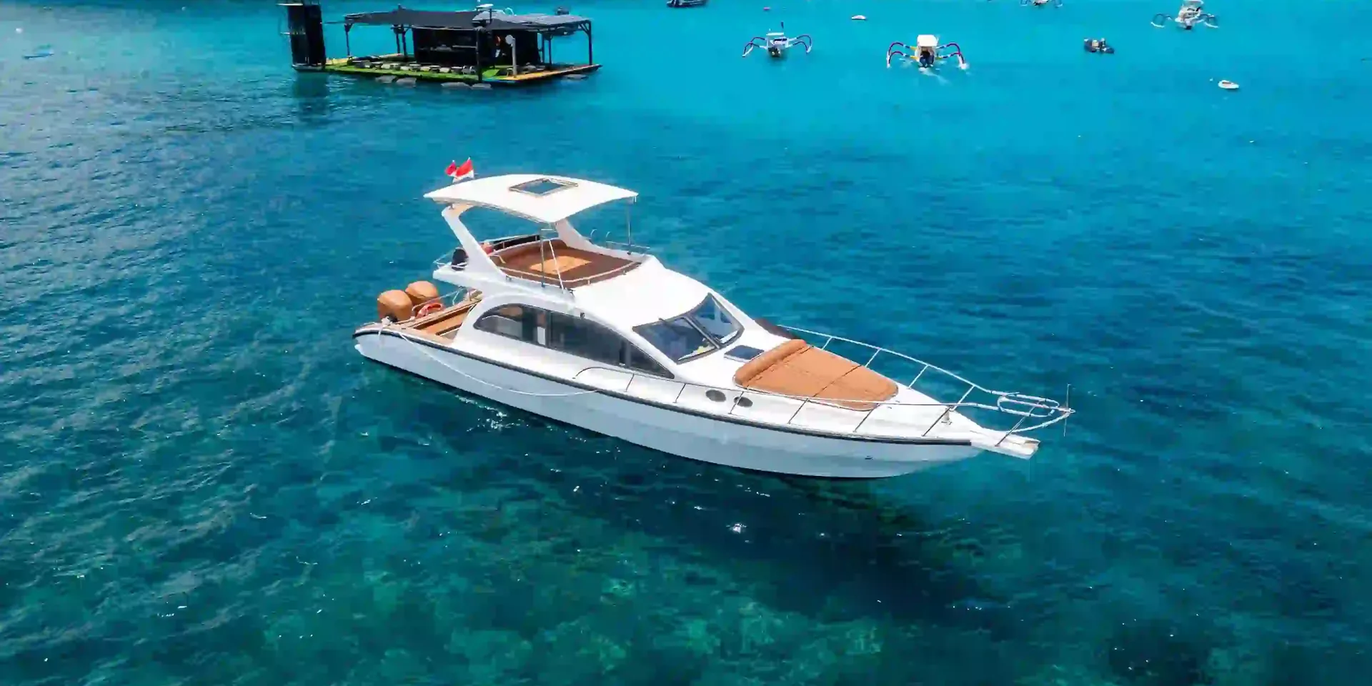 Aerial view of a private motor yacht in turquoise water off Nusa Lembongan